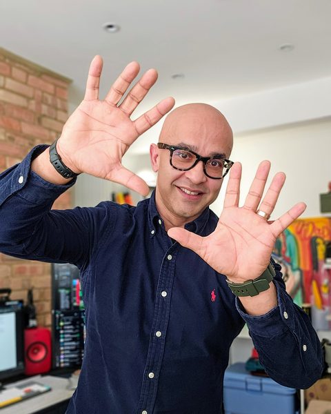 Ferdie Ahmed holding up both hands, in colour